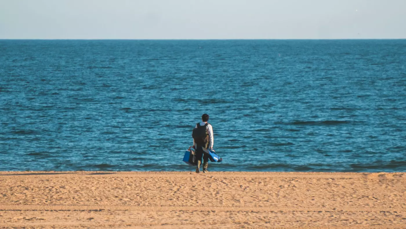 One person walking along an empty beach